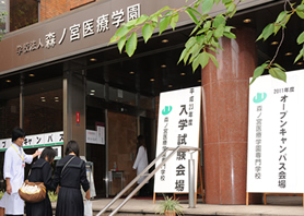 本校舎玄関で学生がお出迎え