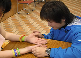 参加者の指の状態を確認する朝倉先生