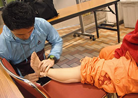足を痛めた参加者にテーピングを施す穴田先生