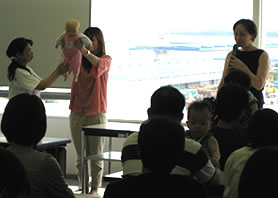 人形を使ってベビーマッサージの指導を行う西山先生