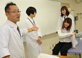 突然、学生に包帯を巻かせる小笠原先生