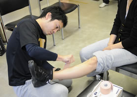足を痛めた参加者にテーピングを施す外林先生