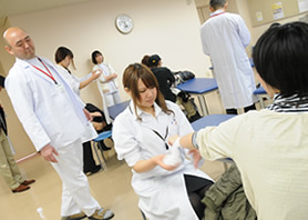 在校生による実技を温かく見守る柔道整復学科の入江先生
